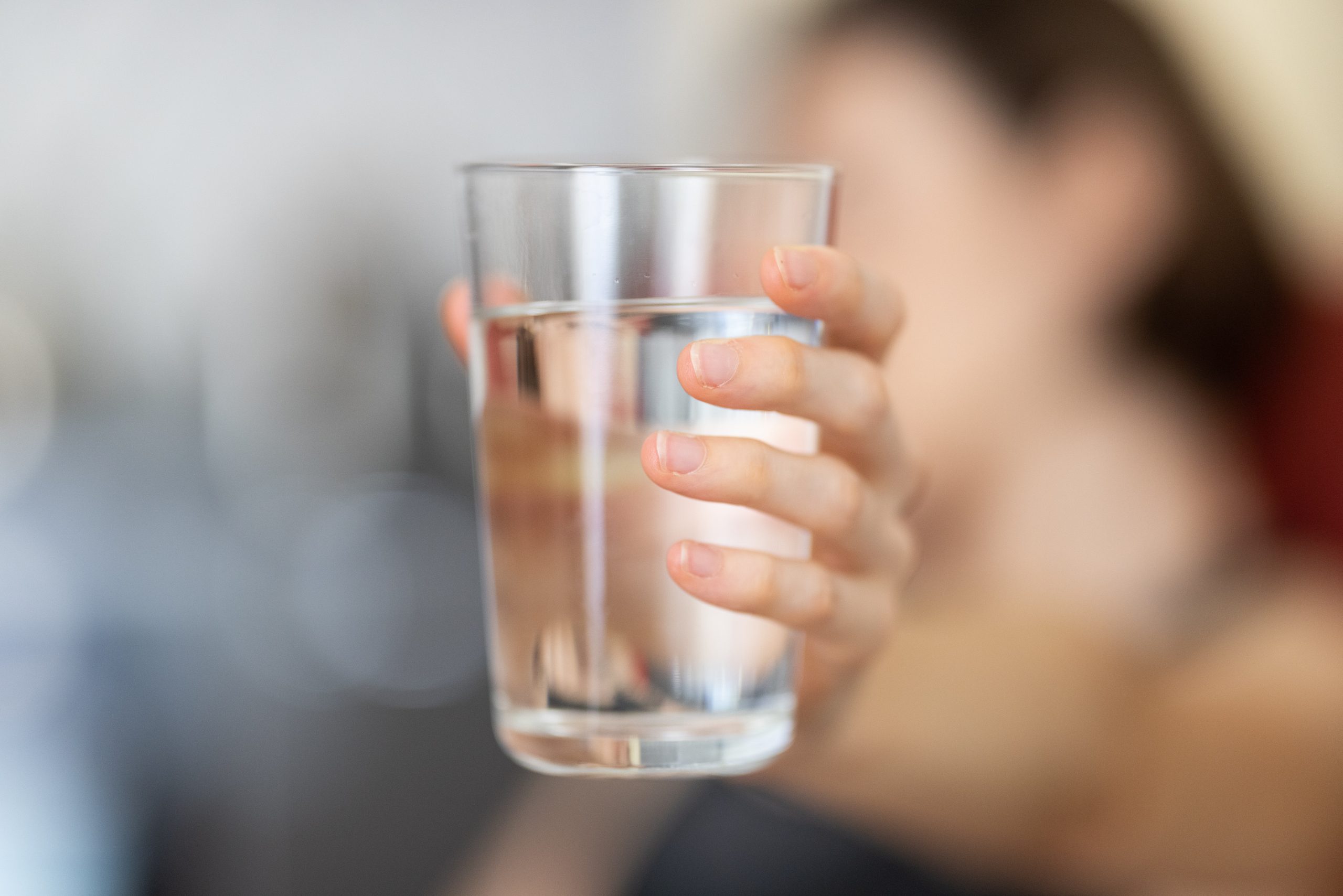 A person holds a glass of water