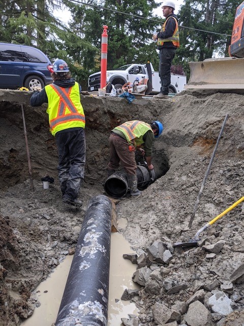 Utility staff work on connecting water mains