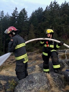Gibsons Fire Department members extinguishing a fire.