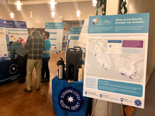 Image shows display boards and Sunshine Coast Regional District staff engaging with the community on the Official Community Plan Renewal Project.