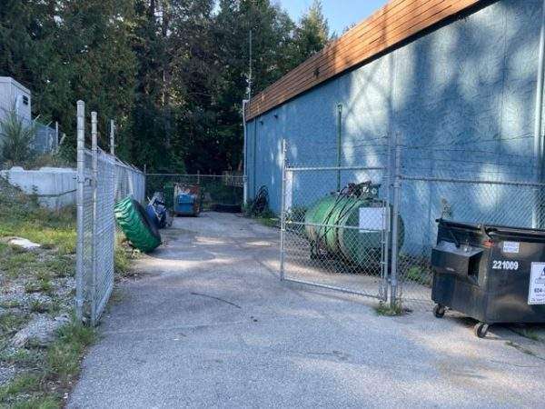 A fuel storage tank behind gates in a yard. 